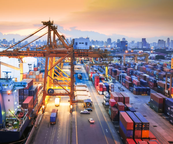 Container Cargo freight ship with working crane bridge in shipyard